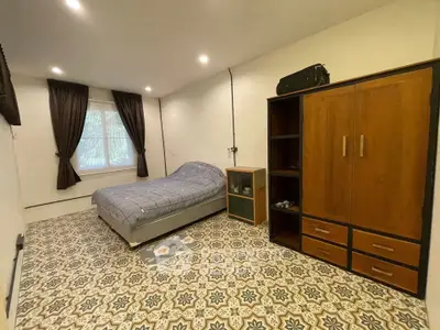 Spacious bedroom with stylish patterned floor and cozy bed setup.