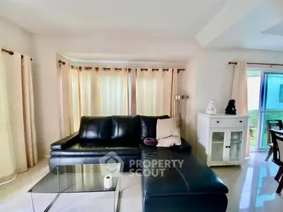 Spacious living room with modern black leather sofa and glass coffee table