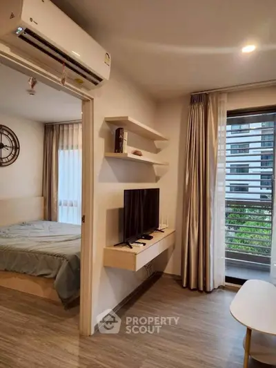 Modern apartment interior with cozy bedroom and stylish living area featuring wall-mounted TV and air conditioning.