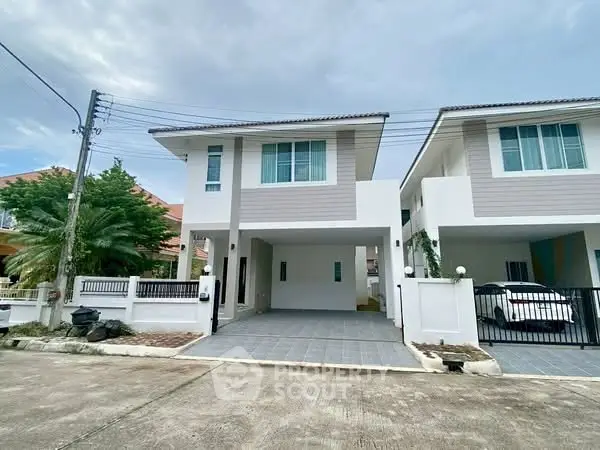 Modern two-story house with driveway and garage in suburban neighborhood.