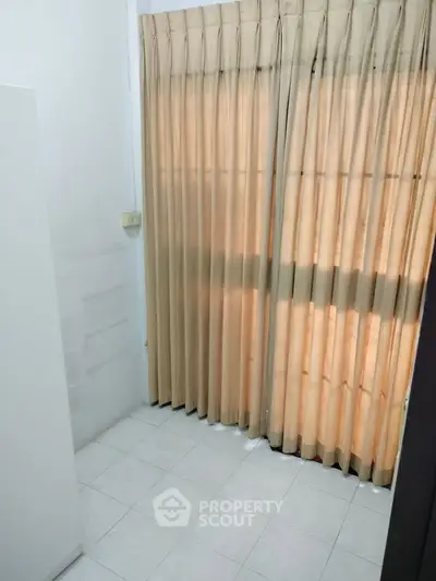 Cozy room with tiled floor and beige curtains, perfect for customization.