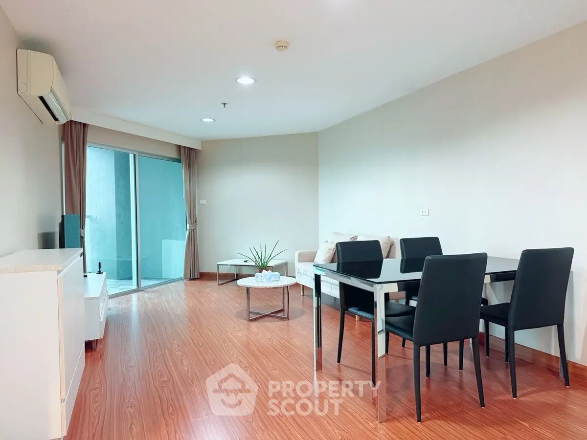 Spacious modern living room with wooden flooring and elegant dining area.