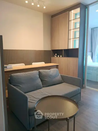 Modern living room with cozy sofa and stylish dining area in open-plan apartment.