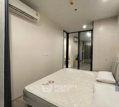 Modern bedroom with air conditioning and mirrored closet doors in a stylish apartment.