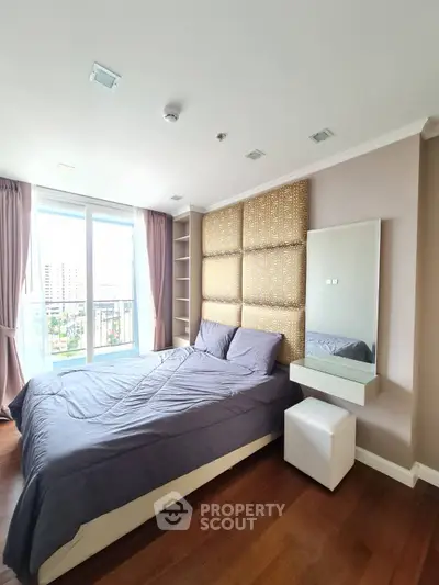 Spacious bedroom with modern decor and large window offering city view