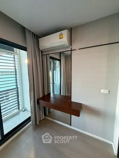 Modern bedroom with air conditioning and balcony access in a stylish apartment.