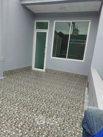 Spacious balcony with modern tiled flooring and large glass door
