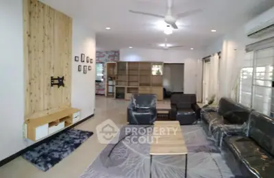 Spacious living room with modern decor and ceiling fan, perfect for family gatherings.