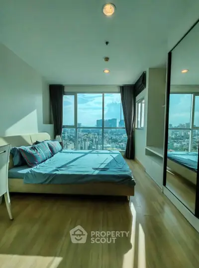 Spacious bedroom with stunning city view and modern furnishings.