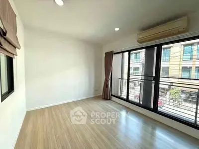 Spacious room with large windows and wooden flooring, perfect for natural light lovers.