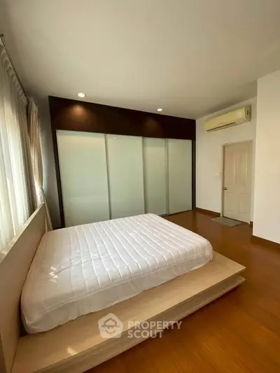 Spacious bedroom with modern design and large windows for natural light.