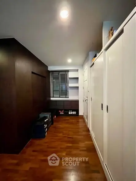 Spacious storage room with wooden flooring and ample shelving.