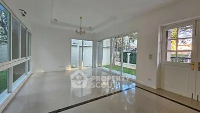 Spacious living room with large windows and garden view, perfect for natural light lovers.