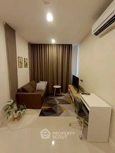 Cozy living room with modern decor and air conditioning, perfect for relaxation.