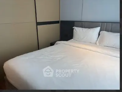 Modern bedroom with sleek design and comfortable bedding in a stylish apartment.