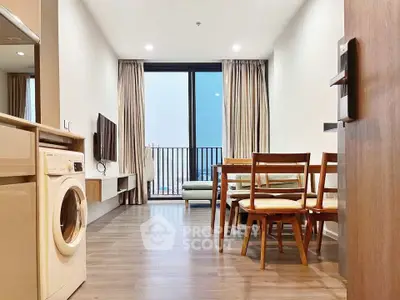 Modern living room with dining area and washing machine, featuring floor-to-ceiling windows and sleek furnishings.
