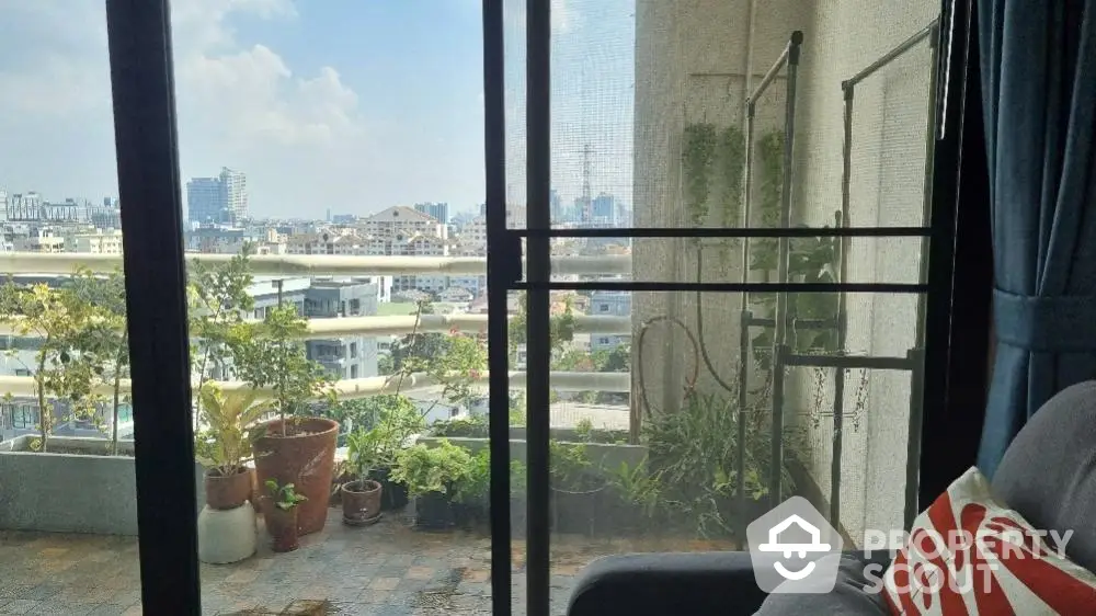 Spacious balcony with urban skyline views, offering a serene outdoor retreat in a bustling city, perfect for relaxation and entertaining.