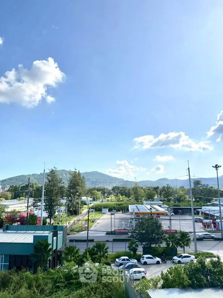 Scenic view of lush greenery and mountains from a property, showcasing serene surroundings and clear skies.