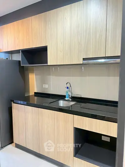 Modern kitchen with sleek wooden cabinets and black countertop