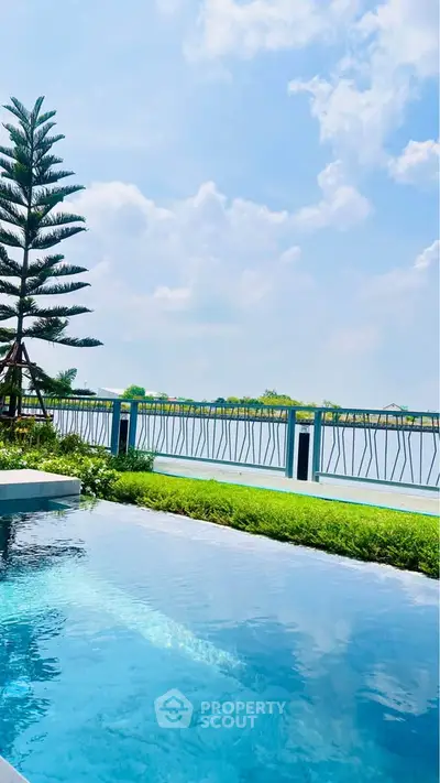 Luxurious poolside view with serene landscape and clear blue sky.