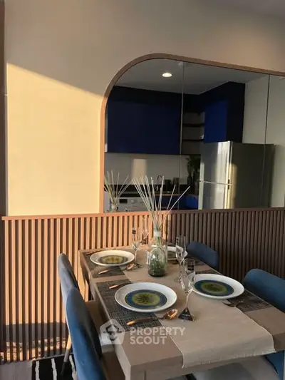 Modern dining area with elegant table setting and stylish kitchen in the background.