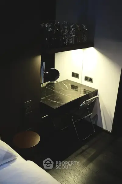 Modern bedroom with sleek black desk and chair, ideal for a stylish home office setup.