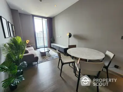 Chic modern living room with elegant dining area, floor-to-ceiling windows, and tasteful decor, offering a comfortable urban living experience.