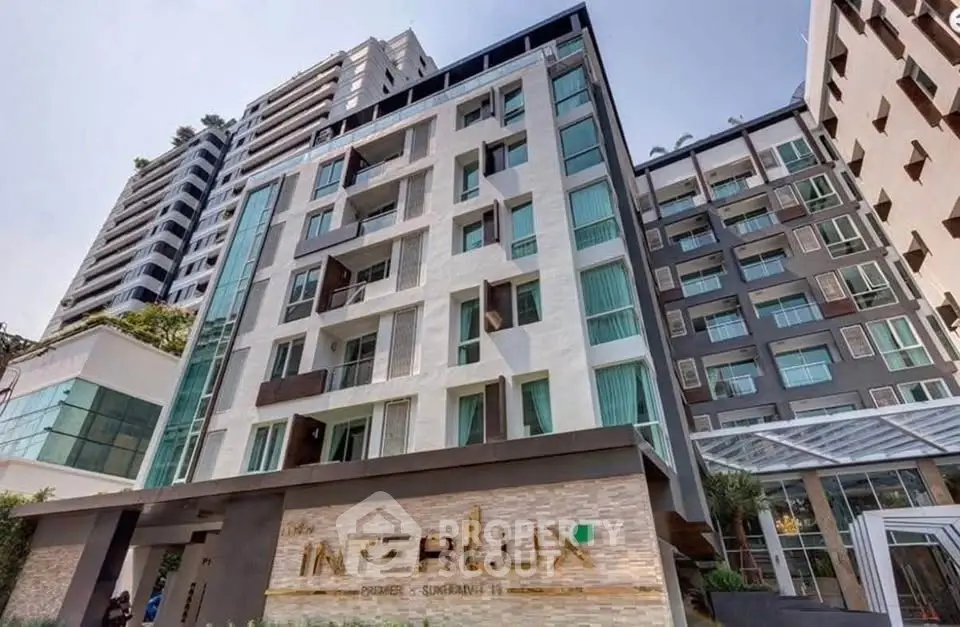 Modern condominium building with sleek design and large windows in urban setting.