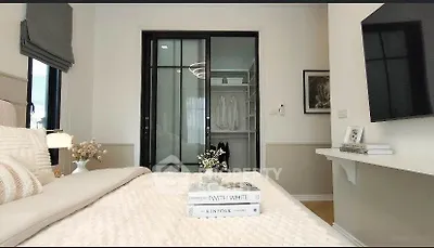 Elegant bedroom with walk-in closet and modern decor, featuring a cozy bed and stylish lighting.