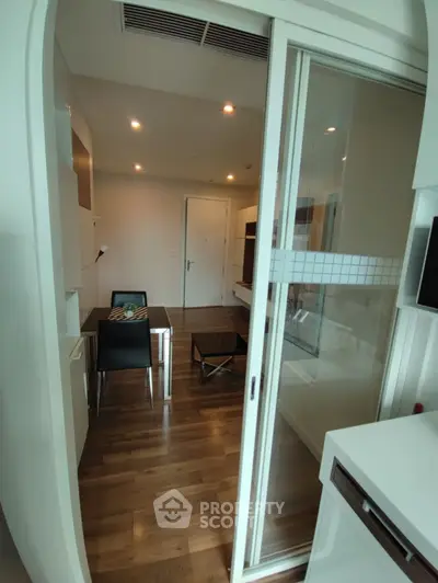 Modern apartment interior with wooden flooring and sliding glass door