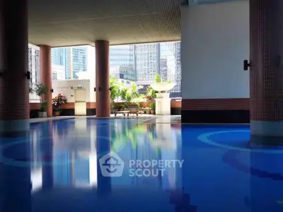 Luxurious indoor pool area with city views and elegant design, perfect for relaxation and leisure.