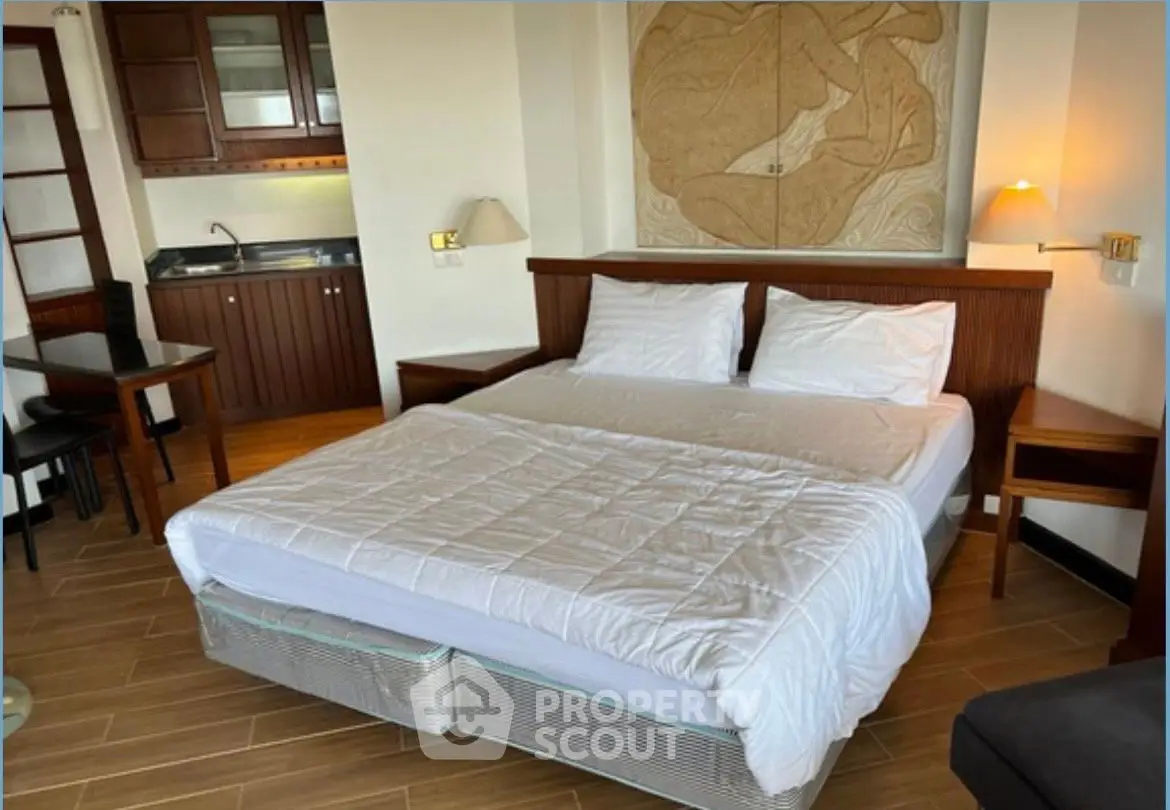 Cozy bedroom with kitchenette and modern decor, perfect for urban living.
