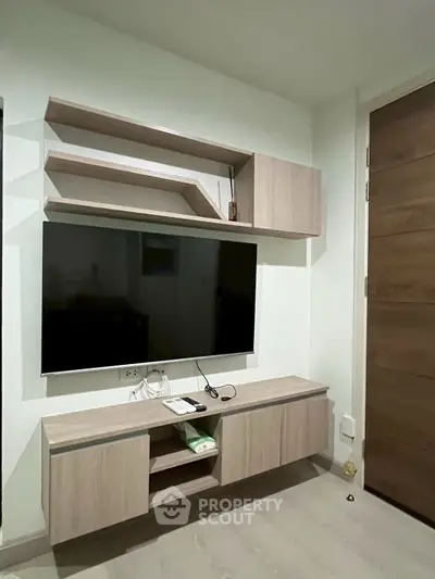 Modern living room with sleek wall-mounted TV and stylish wooden shelves