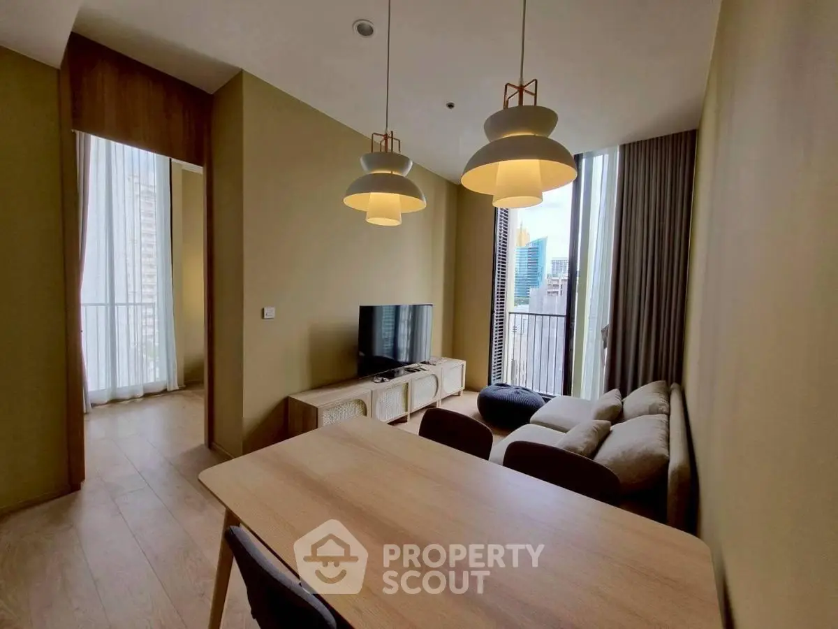 Modern living room with city view, stylish lighting, and cozy seating area.