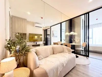 Modern living room with elegant decor and mirrored wall in a stylish apartment.