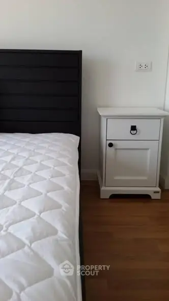 Cozy bedroom with modern black headboard and white nightstand