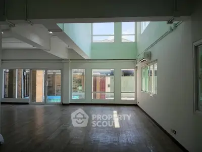 Spacious living room with high ceilings and large windows offering abundant natural light.