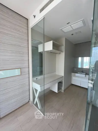 Modern bathroom with glass partition and sleek vanity in luxury apartment