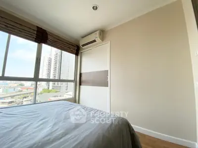 Modern bedroom with large window and city view, featuring built-in wardrobe and air conditioning.
