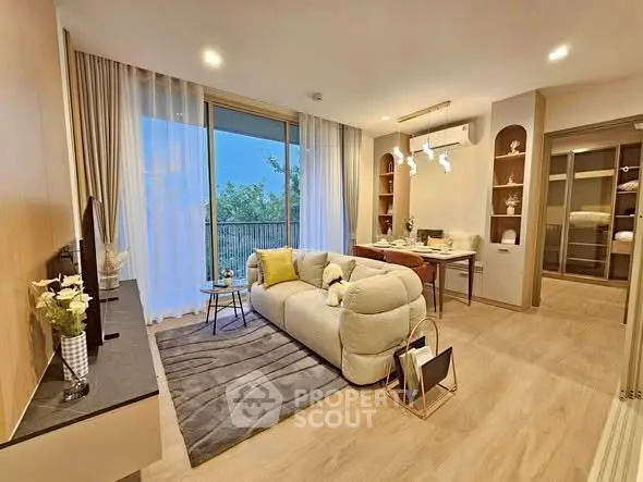 Modern living room with cozy sofa, elegant decor, and large window offering scenic view.