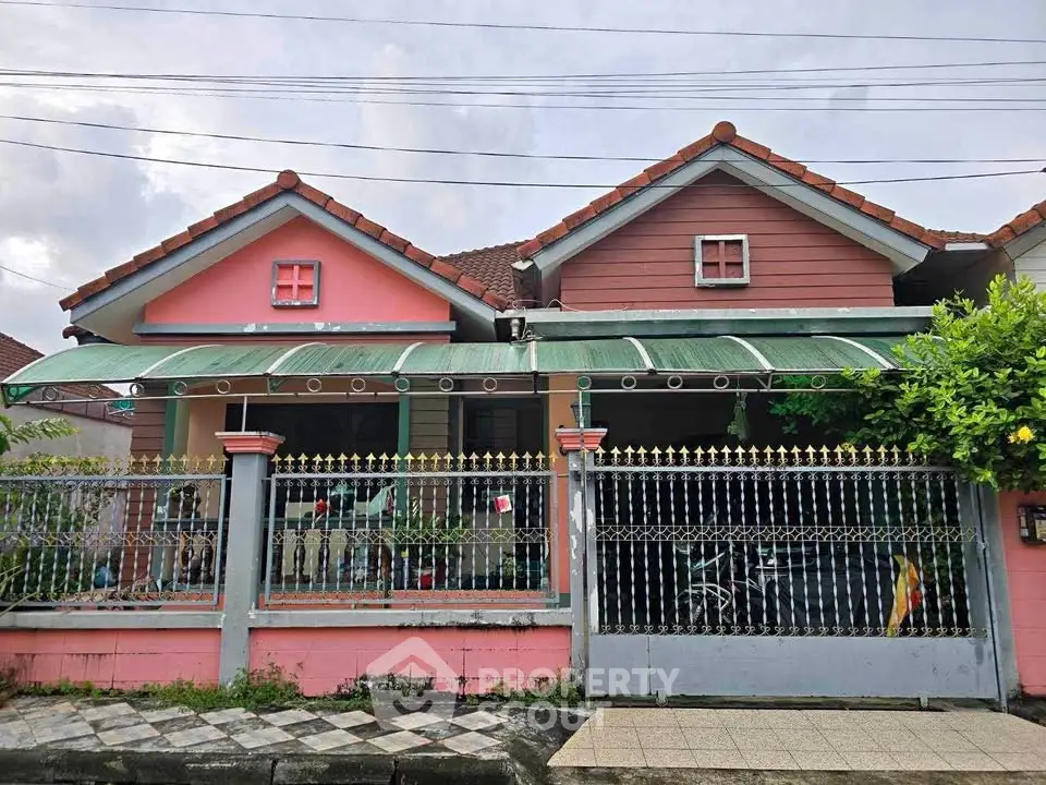 Charming suburban house with a pink facade and decorative fencing, perfect for family living.