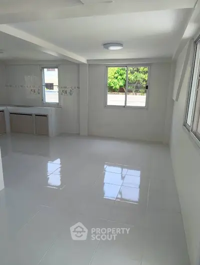 Spacious and bright interior with large windows and tiled flooring, perfect for modern living.