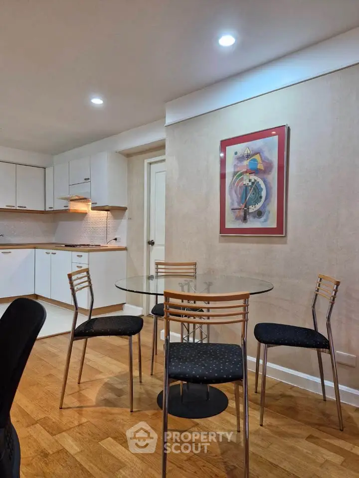 Modern kitchen with dining area featuring sleek glass table and stylish chairs, perfect for contemporary living.