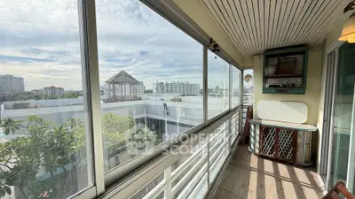 Spacious balcony with panoramic city views and vintage decor, perfect for relaxation and enjoying the skyline.