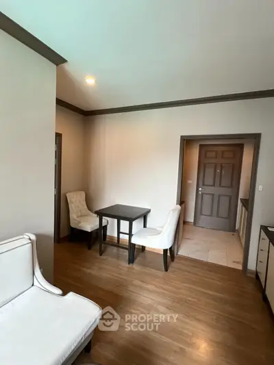 Cozy living room with elegant white chairs and wooden flooring, perfect for relaxation and gatherings.