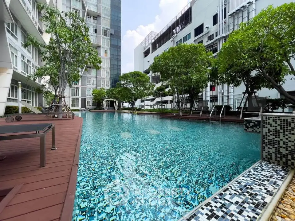 Luxurious condominium pool area with modern design and lush greenery