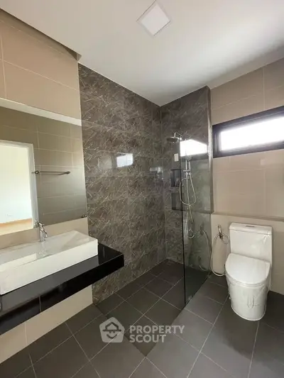 Modern bathroom with sleek design, featuring a glass shower and elegant tile work.