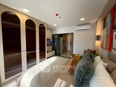 Luxurious bedroom with modern decor and ample natural light, featuring built-in wardrobes and stylish furnishings.