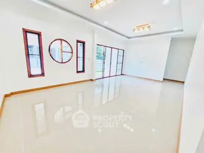 Spacious modern living room with unique window design and glossy tile flooring