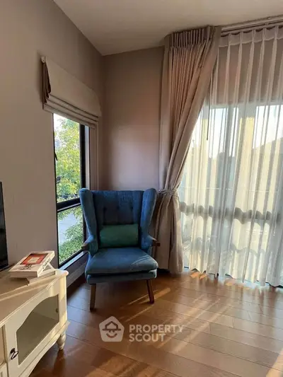 Cozy living room corner with elegant armchair and large window view